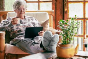 Woman on tablet enjoying the indoor temperatures in her home